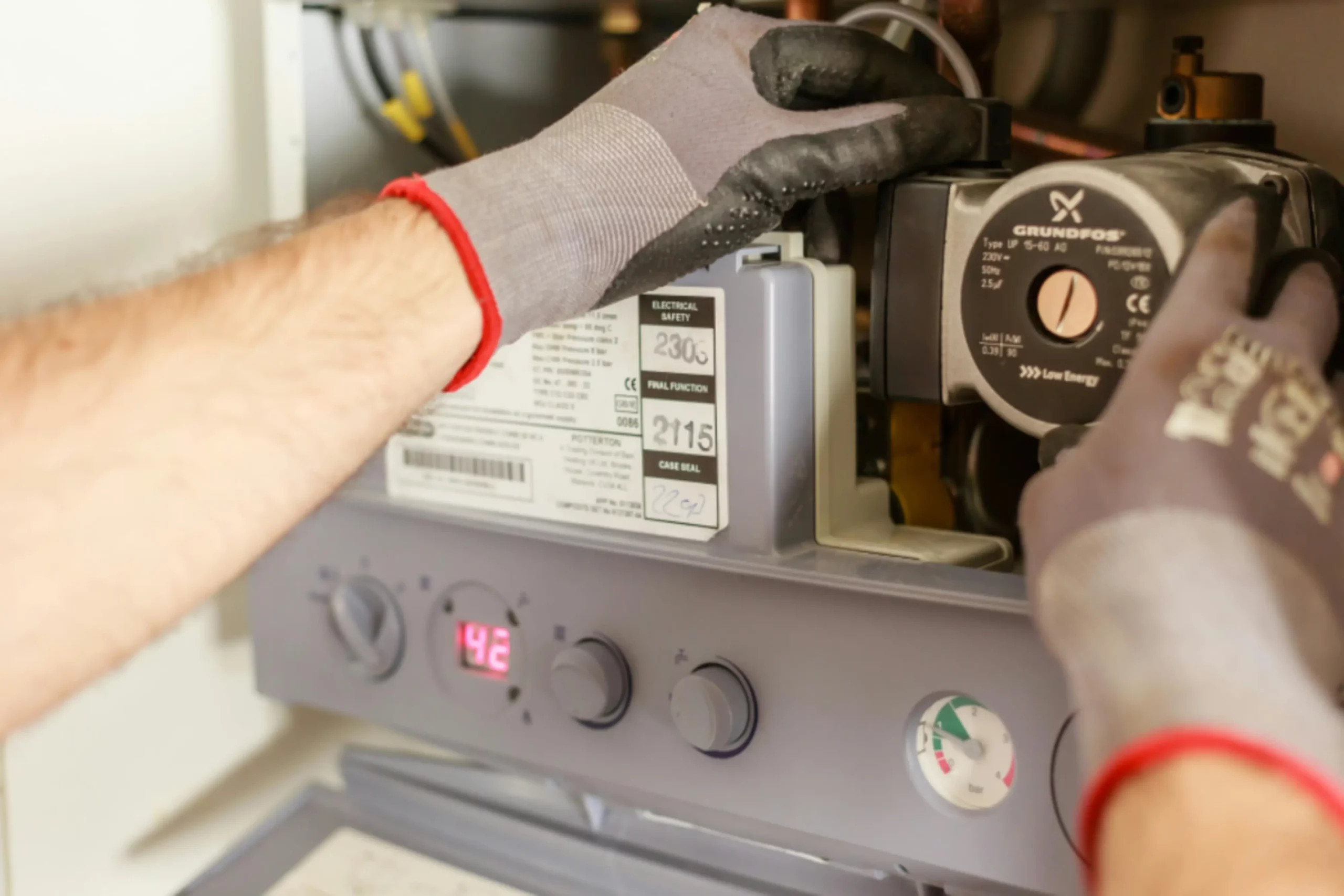 Technicien EP Chauffage effectuant le paramétrage numérique d'un compteur thermique pour optimiser la consommation d'énergie.